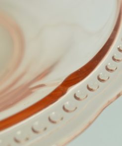 Roze schaal glas met kleine parelrand.
