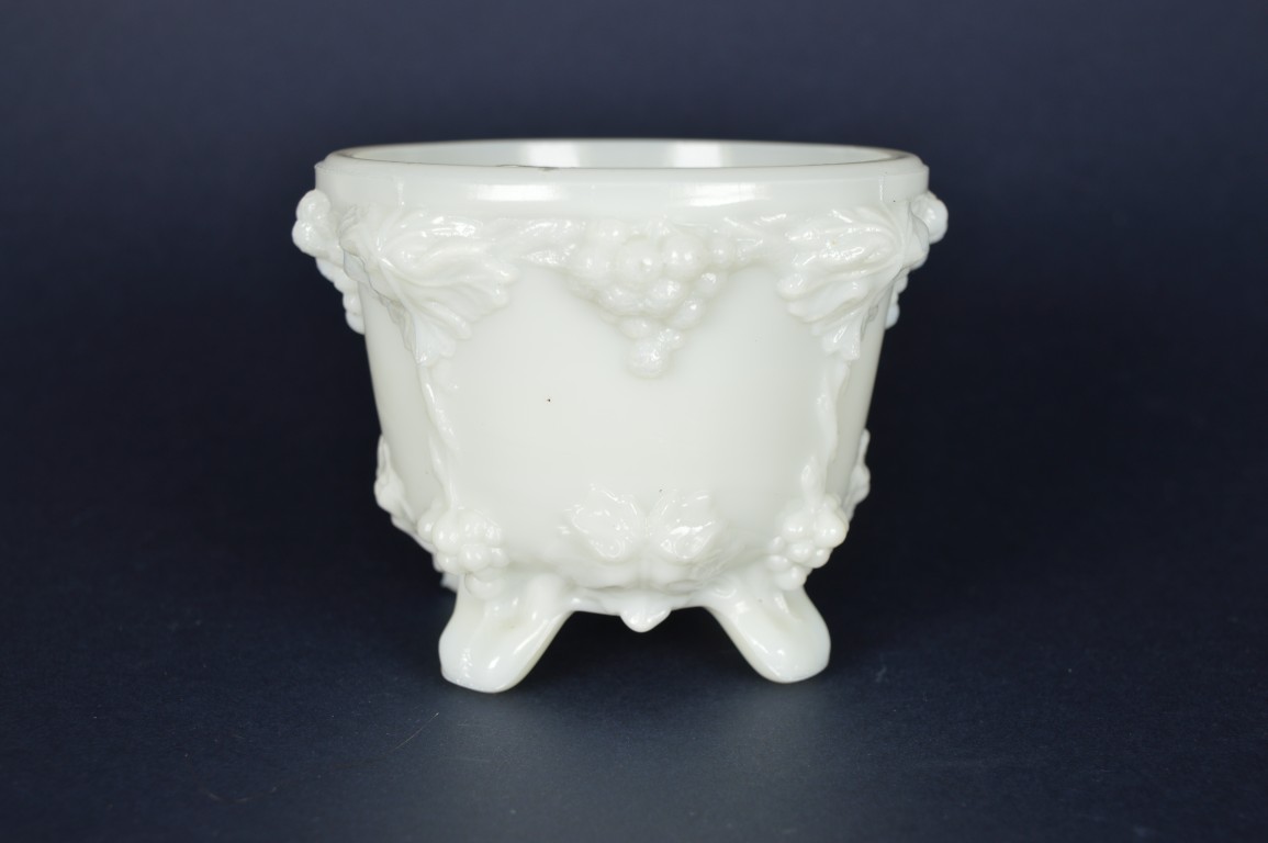 Schaaltje wit melkglas, met druiven op vier voetjes