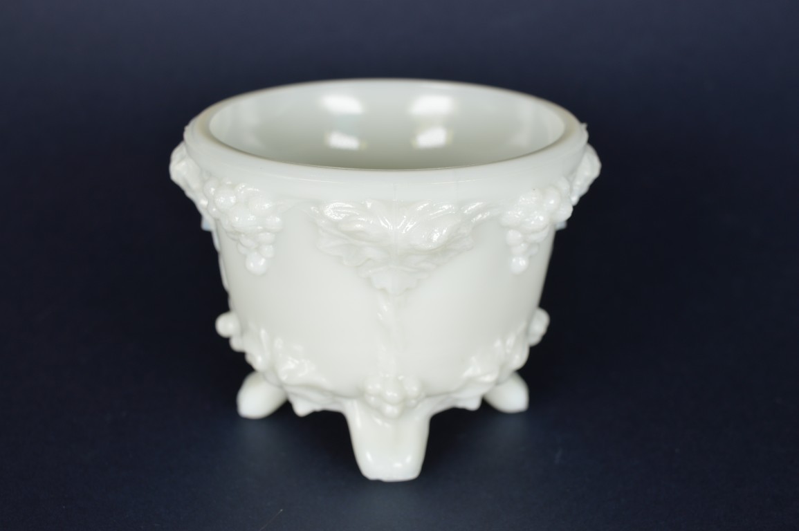 Schaaltje wit melkglas, met druiven op vier voetjes